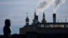 FILE - A woman walks with a power plant in the background, in Vinnytsia, Ukraine, March 16, 2022. Russia launched a cyberattack against a power plant near Kyiv in March 2023 and followed up with a missile strike shortly after the Ukrainian cyber response team arrived. 