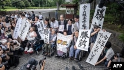 Victims of forced sterilisation under a now-defunct eugenics law, celebrate with lawyers and supporters outside of the Supreme Court of Japan in Tokyo on July 3, 2024. 