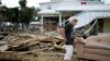 FILE - Tina Brotherton, 88, looks over the remains of her business, Tina's Dockside Inn, which was completely destroyed in Hurricane Idalia, as was Brotherton's nearby home, in Horseshoe Beach, Florida, Sept. 1, 2023. 
