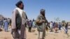 Taliban security personnel stand guard as Afghans mourn at a burial ceremony of the slain Shiite Muslims after gunmen attacked a mosque in Guzara district of Herat province on April 30, 2024.