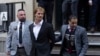 Daniel Penny, center, is walked by New York Police Department detectives detectives out of the 5th Precinct on May 12, 2023, in New York. 
