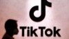 FILE - A visitor passes the TikTok exhibition stands at the Gamescom computer gaming fair in Cologne, Germany, Aug. 25, 2022. 