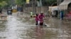 Motorcyclists ride through a flooded street after a heavy rainfall in Lahore, Pakistan, July 1, 2024.