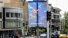 A banner depicting the mythical Persian hero Arash the archer firing a missile from his bow, with text in Persian reading 'I will not abandon my homeland', is displayed along a street in central Tehran on April 15, 2024. 