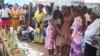 Des parents et des amis se recueillent près de fleurs et de bougies en mémoire des disparus du naufrage d'un ferry au port de Libreville, le 13 mars 2023.