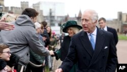 FILE - Britain's King Charles III and Queen Camilla greet people after attending the Easter Matins Service at St. George's Chapel, Windsor Castle, England, March 31, 2024. 
