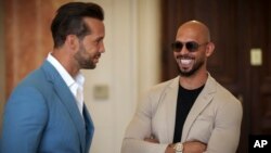 Andrew Tate, right, smiles while waiting along with his brother Tristan for a hearing inside the Court of Appeals building in Bucharest, Romania, June 26, 2024. 