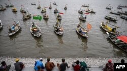 FILE - Fishermen sit on a pier next to their boats on the New Year's holiday in Surabaya on Jan. 1, 2024. Maritime accidents happen regularly in Indonesia, an archipelago of 17,000 islands. 