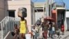 FILE - People walk to a shelter with their belongings, fleeing violence near their homes, in Port-au-Prince, Haiti, March 9, 2024. Due to gang violence, 53,125 people left the city between March 8 and March 27, according to the U.N.’s International Organizations for Migration.