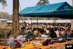 FILE - People fleeing fighting between the Myanmar military and ethnic rebel groups shelter on the Thai side of the Moei river in Mae Sot district in Tak province, April 7, 2023.