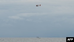 This photo shows a Philippine Coast Guard helicopter flying about two kilometres off the coast of Malolos municipality, Bulacan province on July 29, 2024. A tanker carrying 1.4 million liters of industrial fuel oil sank in bad weather off Manila Bay on early Thursday.