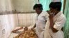 FILE - Nurses talk with a 13 year-old boy with a gunshot wound as he lies in a hospital bed in Kumba, Cameroon, Oct. 25, 2020. Due to superstitious beliefs, blood donations for transfusions in Cameroon have fallen to critically low levels.