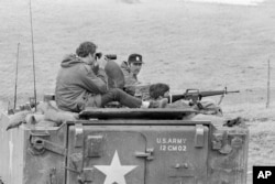 FILE - Government agents maintain watch on American Indian Movement members who have been in control of the village for over three weeks at Wounded Knee, S.D., March 24, 1973.