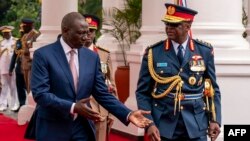 FILE - Chief of Kenya Defense Forces General Francis Ogolla (R) speaks to Kenyan President William Ruto as they prepare to receive Britain's King Charles III and Queen Camilla during the ceremonial welcome at the State House in Nairobi on Oct. 31, 2023.