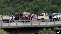 In this image taken from video provided by eNCA, a bus carrying worshipers headed to an Easter festival plunged off a bridge on a mountain pass and burst into flames in Limpopo, South Africa, March 28, 2024, killing multiple people, authorities said.