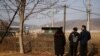 FILE - A North Korean defector and his children stand in front of a barbed wire fence near the demilitarized zone separating the two Koreas, in Paju, Feb. 12, 2021. 