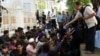 A local official distributes water to Rohingya refugees outside the governor's office in Banda Aceh, Indonesia, Dec. 11, 2023.