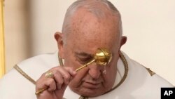 Pope Francis asperses holy water as he celebrates Easter Mass in St. Peter's Square at the Vatican, March 31, 2024. 