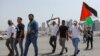 People waving Palestinian flags walk toward the Imam Muhammad bin Abdul Wahhab mosque in Doha, Qatar, on Aug. 2, 2024, for the funeral of Hamas leader Ismail Haniyeh.