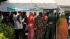 FILE - People queue to collect their elections permanent voters cards at a distribution center.