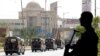 A police officer is silhouetted as he stands guard while paramilitary forces patrol as a security measure, following the visit of the Iranian President Ebrahim Raisi, in Karachi, April 23, 2024. 