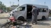 Pakistani investigators examine a damaged van at the site of a suicide attack in Karachi, Pakistan, April 19, 2024. 