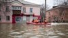Emergency workers and police ride a boat through a flooded street during evacuations after parts of a dam burst, in Orsk, Russia, April 8, 2024.