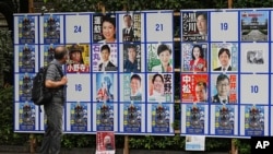 A person looks at an election poster board for the Tokyo gubernatorial election July 1, 2024, in Tokyo. 