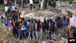 Onlookers gather at the dumpsite where six bodies were found in the landfill in Mukuru slum, Nairobi, July 12, 2024. 