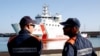 FILE - Italian coast guard officers wait for migrants to disembark from the Italian Coast Guard's patrol vessel Diciotti at the port of Crotone, in the southern Calabria region, Oct. 27, 2022.