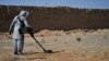 FILE - This picture taken on Nov. 9, 2021 shows a deminer from the HALO (Hazardous Area Life-Support Organization) Trust scanning the ground for mines with a metal detector in Nad-e-Ali village in Helmand province. 