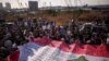 People hold a giant Lebanese flag during a march, as Lebanon marks the fourth anniversary of the explosion in the port of Beirut, Aug. 4, 2024. 