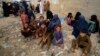 Afghan families wait to board into a bus to depart for their homeland, in Karachi, Pakistan, Oct. 6, 2023.