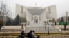 FILE - Commuters ride past the Pakistan's Supreme Court building in Islamabad, Jan. 12, 2024.