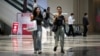 FILE - People walk in a shopping mall in Beijing on June 15, 2023. 