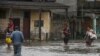 Orang-orang berjalan melalui jalanan yang tergenang banjir setelah dilanda oleh badai Ian di Batabano, Kuba, Selasa 27 September 2022. 