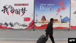 资料照：一名男子走过北京街头张贴的中国梦宣传画。（2017年4月4日）