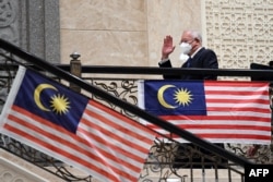Mantan perdana menteri Malaysia Najib Razak melambai saat dia tiba di pengadilan federal di Putrajaya. Pengadilan tertinggi Malaysia pada 23 Agustus 2022 menguatkan hukuman 12 tahun penjara mantan perdana menteri Najib Razak karena korupsi dalam skandal keuangan 1MDB. (Foto: AFP)