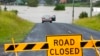 A car is parked near a flooded road at Windsor on the outskirts of Sydney, March 3, 2022.