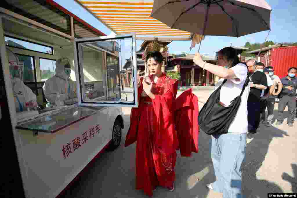 Hengdian World Studios daxilində mobil nuklein turşusu sınaq maşınında COVID-19 üçün sınaqdan keçmək üçün növbədə