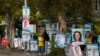 A volunteer stands amongst billboards for candidates outside a polling station in Sydney, Australia, May 9, 2022.
