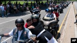 U.S. Marine Corps Staff Sgt. Tim Chambers hugs a participant in the "Rolling to Remember" motorcycle rally on May 29, 2022. Organizers staged the Washington-area ride to spotlight issues facing veterans, demand action for those missing, and raise awareness of the prevalence of suicide among veterans.