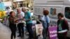 Campaign volunteers address a voter at the entrance to an Australian Electoral Commission early voting center ahead of the national election, in the Central Business District of Sydney, May 17, 2022. 