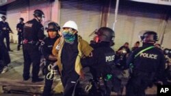 FILE - May 31, 2020 photo, Los Angeles police officers arrest a demonstrator in Los Angeles. The Los Angeles Police Department is investigating 56 allegations of misconduct during protests against police brutality in the wake of George Floyd's death.