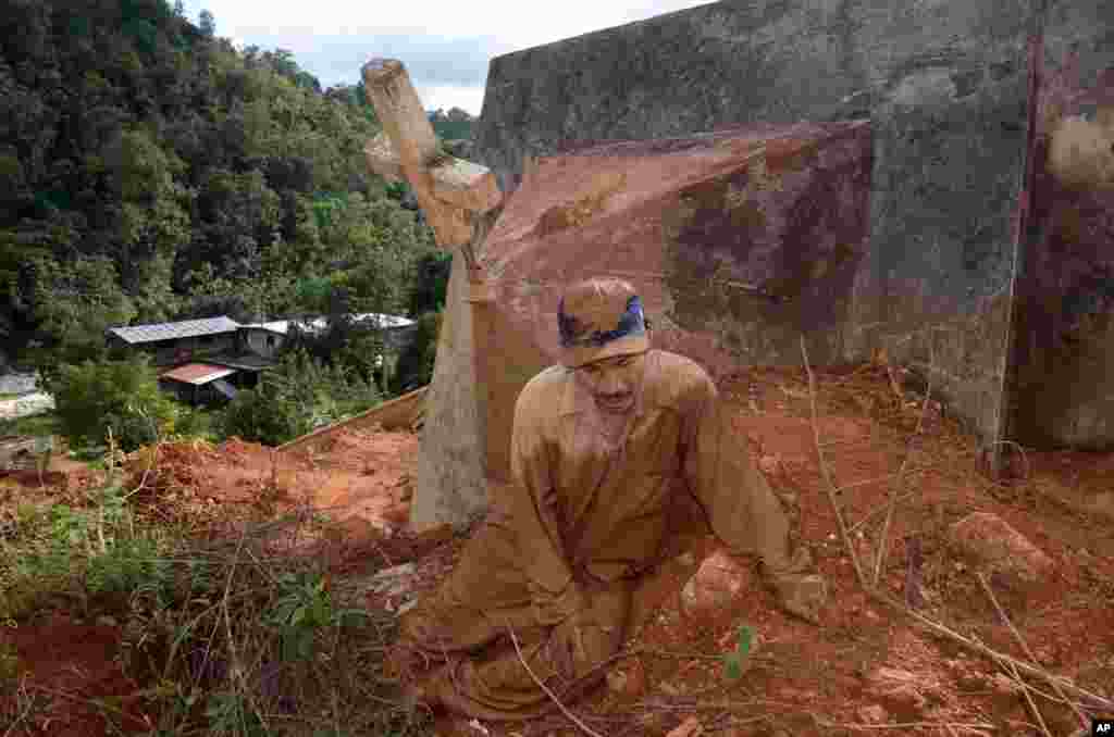 Lazaro Martinez duduk di lumpur sambil terus mencari istri dan dua anaknya di kota La Pintada, Mexico, 1 November 2013. Penduduk desa meminta pemerintah meneruskan pencarian mayat setelah lumpur longsor mengubur belasan orang dalam badai tropis Manuel lebihi dari sebulan lalu.