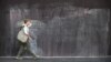FILE - A woman walks past graffiti on an immigration detention hotel in Melbourne on March 24, 2022.