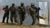FILE - Somali soldiers search through homes for al-Shabaab fighters, during an operation in Ealsha Biyaha, Somalia, June, 2, 2012. On Tuesday, Somali forces attacked a base of the militant group north of Kismayo.