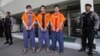 FILE - Suspected Islamic militants, from left to righ: Abdullah, Ahmet Mahmud and Abdulbasit Tuzer, escorted by police, wait for their transport to the prison after a sentencing hearing at North Jakarta District Court in Jakarta, Indonesia, July 13, 2015.