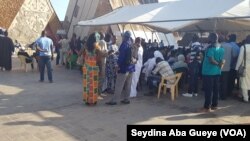 Une centaine de personnes font la queue pour accéder à la salle d'enrôlement à Dakar, au Sénégal, le 14 septembre 2018. (VOA/Seydina Aba Gueye)