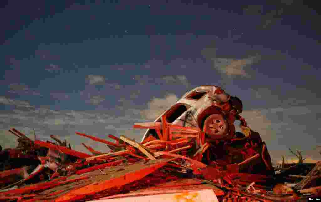 Sebuah kendaraan tersangkut di tumpukan kerusakan yang disebabkan oleh tornado yang melanda Washington, Illinois, USA, 17 November 2013.